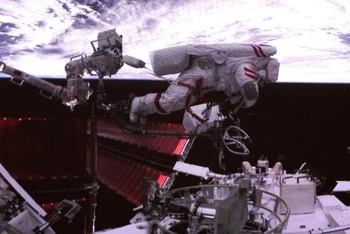 Phi hành gia Phí Tuấn Long đang thao tác lắp đặt ngoài không gian. (Ảnh: Tân Hoa Xã)