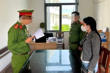 Công an quận Thanh Khê tống đạt quyết định khởi tố bị can đối với Trương Thị Vân Anh. (Ảnh: Công an cung cấp)