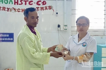 Đại diện Bệnh viện Nhi Gia Lai trao tiền hỗ trợ của các nhà hảo tâm cho đại diện gia đình 3 em nhỏ bị ngộ độc do ăn thịt cóc.