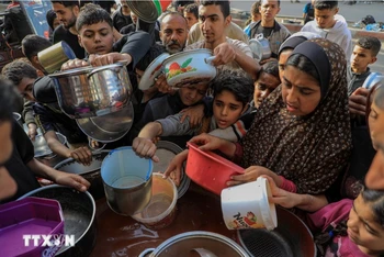 Người dân chờ nhận thức ăn cứu trợ tại thành phố Rafah, Dải Gaza, ngày 30/3/2024. Ảnh: THX/TTXVN.