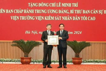 Đồng chí Nguyễn Văn Thể, Bí thư Đảng ủy Khối các Cơ quan Trung ương trao Huy hiệu 40 năm tuổi Đảng và tặng hoa chúc mừng đồng chí Lê Minh Trí, Viện trưởng Viện Kiểm sát nhân dân tối cao.