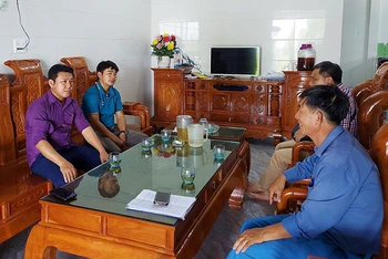 Cán bộ lãnh đạo xã Quảng Đông, huyện Quảng Trạch (Quảng Bình) trò chuyện với một hộ dân ở khu tái định cư thôn Vịnh Sơn.