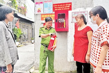 Công an phường Tân Chánh Hiệp hướng dẫn người dân sử dụng bình chữa cháy trong quá trình triển khai mô hình “Tổ liên gia an toàn phòng cháy chữa cháy”. 