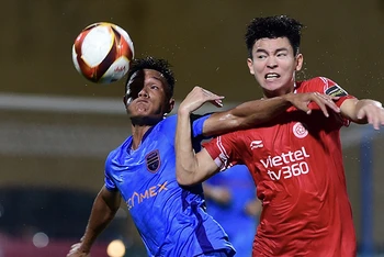 Pha tranh bóng giữa cầu thủ hai đội Viettel FC (áo đỏ) và Becamex Bình Dương. (Ảnh THANH HẢI)