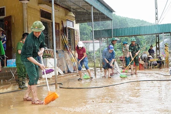 Lực lượng công an, bộ đội huyện Quỳ Châu (Nghệ An) giúp vệ sinh môi trường sau lũ tại điểm Trường mầm non Tà Sỏi, xã Châu Hạnh.