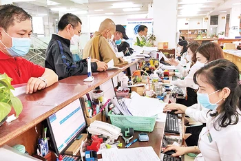 Cán bộ Bảo hiểm xã hội Thành phố Hồ Chí Minh giải quyết thủ tục cho người dân.