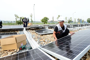 Lắp đặt điện mặt trời áp mái tại Nhà máy nước mặt Sông Đuống. (Ảnh TRẦN QUỐC)