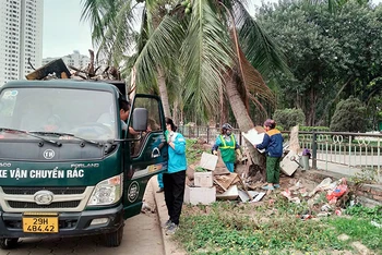 Công nhân môi trường đô thị thu gom rác thải tại khu vực hồ Linh Đàm (quận Hoàng Mai, Hà Nội). (Ảnh ÁI VÂN)