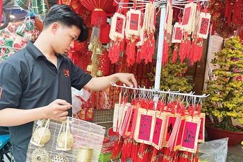 Khách hàng lựa chọn đồ trang trí Tết thuần Việt bày bán trên đường Hải Thượng Lãn Ông, Quận 5.
