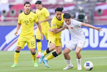 U23 Việt Nam (áo trắng) vào tứ kết sau chiến thắng 2-0 trước U23 Malaysia (Ảnh AFC)