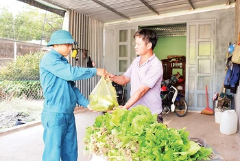 Dân quân xã biên giới Thanh Hòa (huyện Bù Đốp, tỉnh Bình Phước) tặng người dân rau xanh do đơn vị tăng gia.