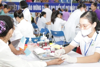 Các y, bác sĩ test đường máu cho người dân trên địa bàn huyện Ba Vì để phát hiện bệnh đái tháo đường