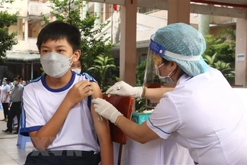 Nhân viên y tế tiêm vaccine cho học sinh lớp 6 tại Trường THCS Lê Quý Đôn, thành phố Vĩnh Long. (Ảnh: TTXVN)