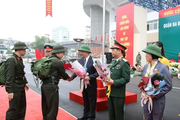 Bí thư Thành ủy Hà Nội Đinh Tiến Dũng tặng hoa cho các tân binh. 