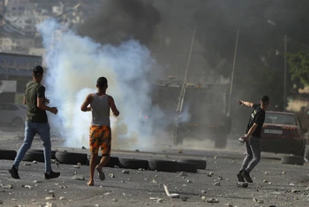 Người biểu tình Palestine ném đá trong cuộc xung đột với binh sỹ Israel tại thành phố Nablus, Khu Bờ Tây ngày 17/8/2022. (Ảnh minh họa: AFP/TTXVN)