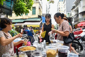 Cảnh mua bán diễn ra tấp nập tại chợ, rượu nếp vẫn là mặt hàng thu hút người mua nhất trong ngày Tết Đoan Ngọ năm nay.