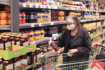 Một phụ nữ lớn tuổi mua sắm tại siêu thị ở Đức. Ảnh: Reuters