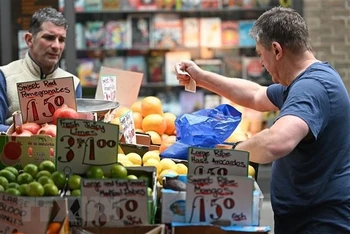Người dân mua sắm tại một chợ ở London, Anh. (Ảnh: AFP/TTXVN)
