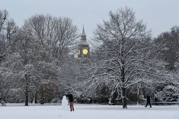 Một người đắp người tuyết khi thời tiết lạnh tiếp tục kéo dài ở London, Anh. Ảnh: REUTERS