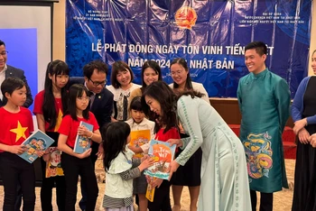 Thứ trưởng Bộ Ngoại giao Lê Thị Thu Hằng, Chủ nhiệm Ủy ban Nhà nước về NVNONN tặng sách tiếng Việt cho các em nhỏ tại Nhật Bản. Ảnh: VGP