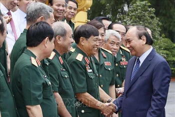 Chủ tịch nước Nguyễn Xuân Phúc với các đại biểu Ban liên lạc Hội Cựu chiến binh toàn quốc mặt trận Vị Xuyên-Hà Tuyên. (Ảnh: Thống Nhất/TTXVN)