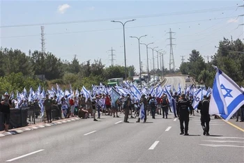 Người biểu tình tập trung tại Quốc lộ 443, gần thành phố Modiin, Israel ngày 11/7. (Ảnh: AFP/TTXVN)
