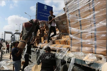Người dân chuyển hàng cứu trợ nhân đạo tại cửa khẩu Rafah ở Dải Gaza ngày 2/11/2023. (Ảnh: THX/TTXVN)