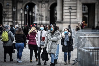 Người dân và du khách đeo khẩu trang phòng tránh lây nhiễm Covid-19 tại Paris, Pháp, đầu năm 2020. (Ảnh: AFP/TTXVN) 