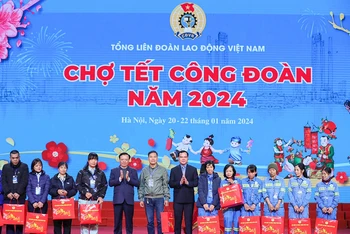 Đồng chí Đinh Tiến Dũng, Ủy viên Bộ Chính trị, Bí thư Thành ủy Hà Nội và lãnh đạo Tổng LĐLĐ Việt Nam trao quà Tết tặng công nhân, người lao động có hoàn cảnh khó khăn tại phiên Chợ Tết Công đoàn năm 2024. 