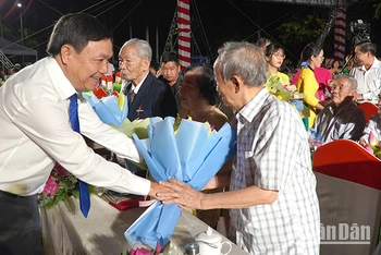Phó Bí thư Thường trực Tỉnh ủy Đồng Tháp Phan Văn Thắng tặng hoa nhân chứng lịch sử. (Ảnh: HỮU NGHĨA)