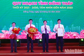 Phó Thủ tướng Lê Minh Khái trao Quyết định của Thủ tướng Chính phủ về công tác Quy hoạch tỉnh Đồng Tháp thời kỳ 2021-2030, tầm nhìn đến năm 2050 cho lãnh đạo tỉnh. Ảnh: HỮU NGHĨA