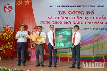 Chủ tịch Ủy ban nhân dân tỉnh Đồng Tháp Phạm Thiện Nghĩa trao quyết định công nhận xã nông thôn mới nâng cao. (Ảnh: HỮU NGHĨA)