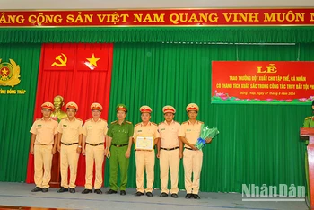 Lãnh đạo Công an huyện Cái Bè, tỉnh Tiền Giang và lãnh đạo Phòng Cảnh sát giao thông, Công an tỉnh Đồng Tháp trao giấy khen cho tập thể có thành tích trong bắt các đối tượng cướp và cố ý gây thương tích. (Ảnh: PHƯỚC THANH)