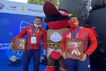 Kình ngư Võ Huỳnh Anh Khoa (phải) chụp ảnh cùng đồng đội sau khi xuất sắc giành Huy chương Vàng đầu tiên cho Đoàn thể thao người khuyết tật Việt Nam tại ASEAN Para Games, ngày 1/8/2022. (Ảnh: Chiến Phong/TTXVN)