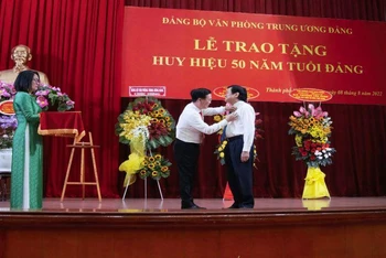Đồng chí Võ Văn Thưởng, Thường trực Ban Bí thư trao Huy hiệu 50 năm tuổi Đảng cho nguyên Chủ tịch nước Trương Tấn Sang.