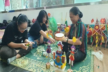 Nghệ nhân Nguyễn Thị Tuyến đang hướng dẫn cách làm đồ chơi trung thu cho du khách.