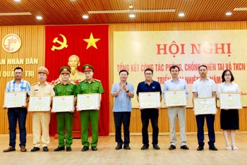 Đại diện Báo Nhân Dân (thứ 3 phải qua) nhận Bằng khen của Chủ tịch Ủy ban nhân dân tỉnh Quảng Trị, vì có nhiều đóng góp tuyên truyền trong công tác phòng, chống thiên tai.