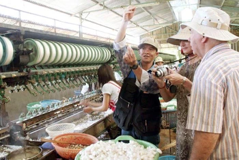Du khách nước ngoài tham quan làng nghề ươm tơ dệt lụa thị trấn Nam Ban, huyện Lâm Hà, Lâm Đồng.