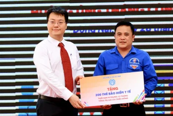 Đại diện Bảo hiểm Xã hội Việt Nam trao bảng biểu trưng 300 thẻ bảo hiểm y tế cho Tỉnh đoàn Đồng Nai.