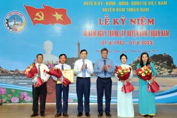 Đại diện lãnh đạo tỉnh Bình Thuận trao Bằng khen của Chủ tịch Ủy ban nhân dân tỉnh và tặng hoa chúc mừng cán bộ, nhân dân huyện Hàm Thuận Nam.