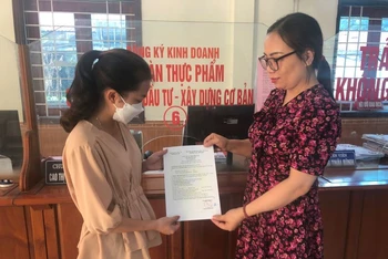 Công chức Bộ phận một cửa huyện Nghi Lộc (Nghệ An) trao Giấy chứng nhận đăng ký hộ kinh doanh cho người dân.