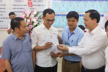 Anh Đinh Tiến Hoàng (huyện Thanh Liêm, Hà Nam) nhận giấy khai sinh và thẻ bảo hiểm y tế cho con gái mới sinh, sau khi làm thủ tục hành chính liên thông.