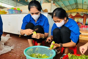 Các tình nguyện viên của Đoàn Thanh niên Thị trấn Chư Ty (huyện Đức Cơ) nấu ăn miễn phí cho các sĩ tử. (Ảnh Phan Lài) 