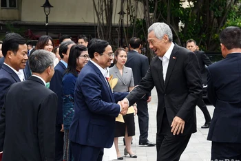 Thủ tướng Phạm Minh Chính và lãnh đạo Đại học Quốc gia Hà Nội đón Thủ tướng Singapore Lý Hiển Long cùng phu nhân.