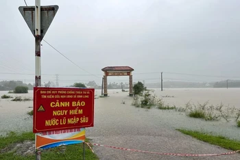 Chính quyền địa phương ở huyện Bình Sơn (Quảng Ngãi) rào chắn, cắm biển cảnh báo nguy hiểm trên các tuyến đường bị ngập lụt. 