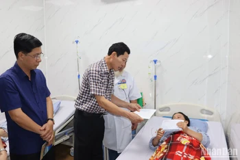 Đồng chí Võ Thanh An thăm hỏi và trao quà cho nữ lao công Võ Thị Lưu.
