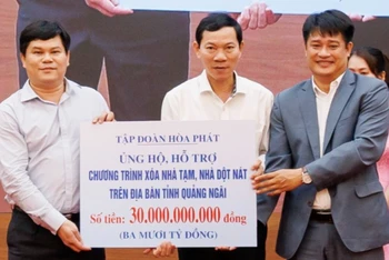 Ông Vũ Xuân Hà, đại diện Công ty cổ phần thép Hòa Phát Dung Quất và Tập đoàn Hòa Phát trao biểu trưng ủng hộ 30 tỷ đồng cho tỉnh Quảng Ngãi triển khai chương trình xóa nhà tạm, nhà dột nát.