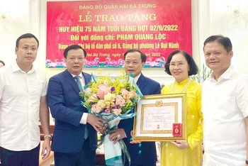 Bí thư Thành ủy Hà Nội Đinh Tiến Dũng trao Huy hiệu 75 năm tuổi Đảng cho đại diện gia đình đồng chí Phạm Quang Lộc.