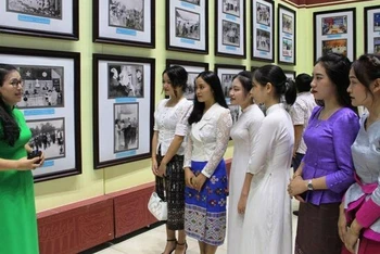 Sinh viên Việt-Lào nghe thuyết minh, giới thiệu ảnh về truyền thống hữu nghị Việt-Lào.