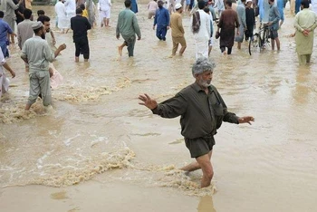 Người dân di chuyển trên con đường bị ngập tại Charsadda, Pakistan. (Ảnh: Reuters)